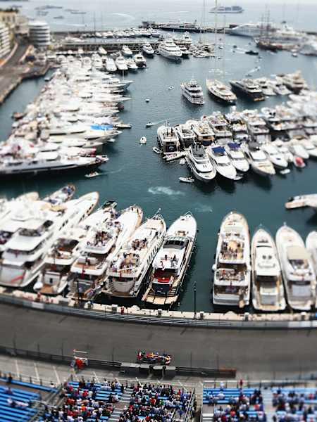 Grand Prix Monako F1 - bolid mknie po ulicach Monte Carlo, w tle marina i zatoka