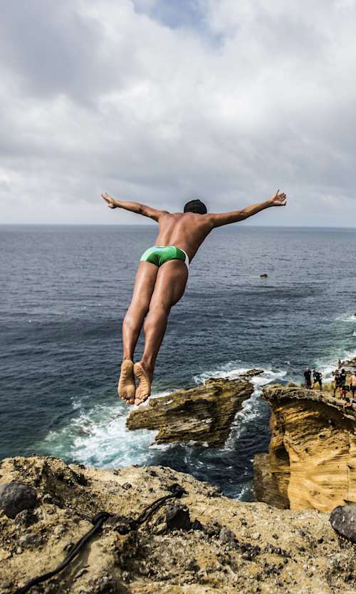 Jucelino Junior of Brazil dives from the 25 metre Snakehead rock during the first training session of the fifth stop of the Red Bull Cliff Diving World Series, Islet Franco do Campo, Azores, Portugal