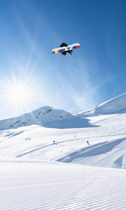 Jake Canter catches massive air with a backside 180 during the Red Bull Performance camp at Saas-Fee, Switzerland, on September 28, 2025, under clear alpine skies and stunning snow-capped peaks.