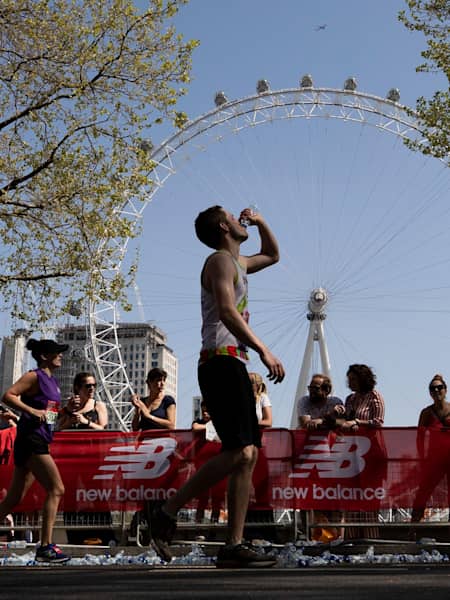 A runner drinking water during a marathon