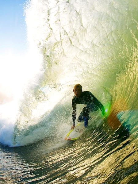 Your newest inductee into the Order of Australia, Mick Fanning, surfing a large tube with the sun behind it.