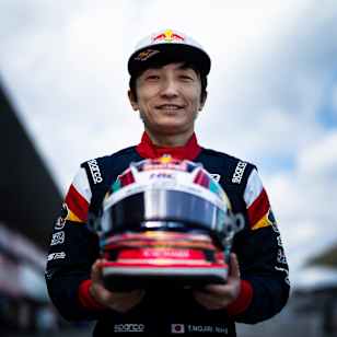Tomoki Nojiri, Red Bull athlete, smiles holding helmet at Suzuka Circuit in 2024.