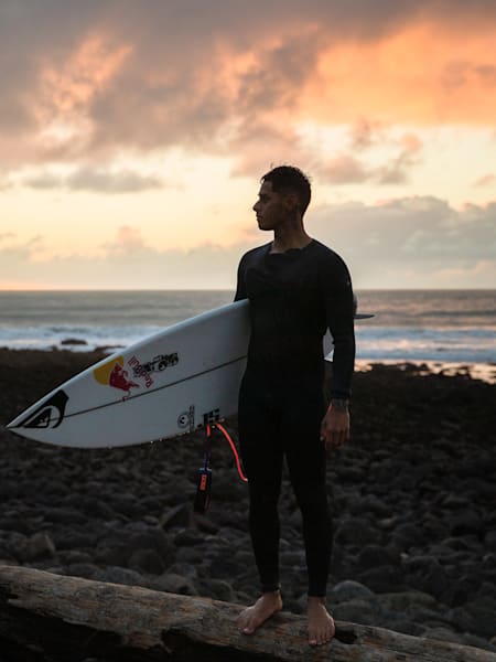 Kehu Butler standing at a surf beach in Aotearoa
