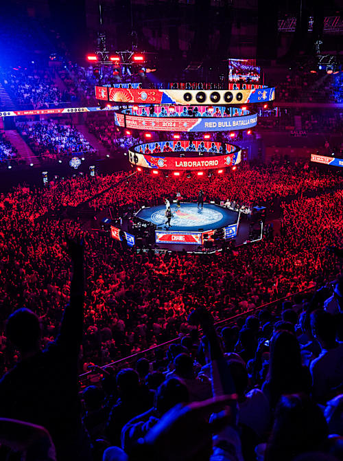 A packed crowd cheers at the Red Bull Batalla World Final 2024 in Madrid, Spain, where freestyle MCs battle under vibrant lights, capturing Red Bull's legendary high-energy atmosphere