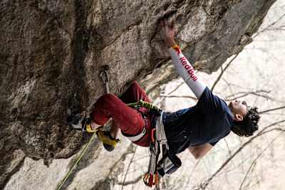 Alpinistul Darius Rapa escaladează o stâncă.