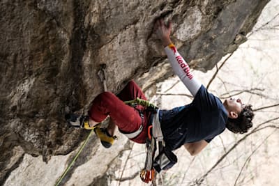 Alpinistul Darius Rapa escaladează o stâncă.