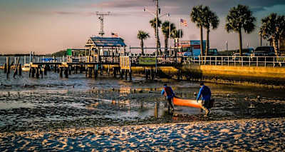 Competitors carry kayak towards the sea in Florida.