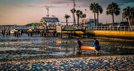 Competitors carry kayak towards the sea in Florida.