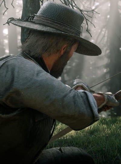 A promotional screenshot of Arthur Morgan hunting deer in Red Dead Redemption 2