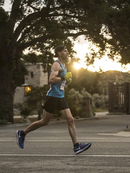 Un atleta corre sobre asfalto.