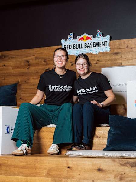 Im Jahr 2024 posieren zwei lächelnde SoftSocket-Gewinner beim Red Bull Basement Event in Zürich, Schweiz, umgeben von Sponsorenlogos