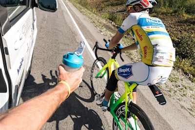 ライダーにドリンクを手渡すサポートクルー