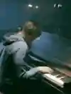 An image of a member of AWOLNATION playing a piano in the video for Sail.