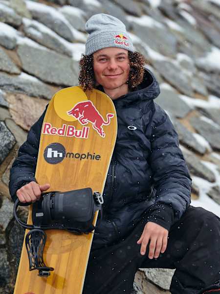 On August 27, 2025, Red Bull athlete Valentino Guseli holds his branded snowboard in snowy Perisher, Australia, sporting cold weather gear during an exciting winter adventure