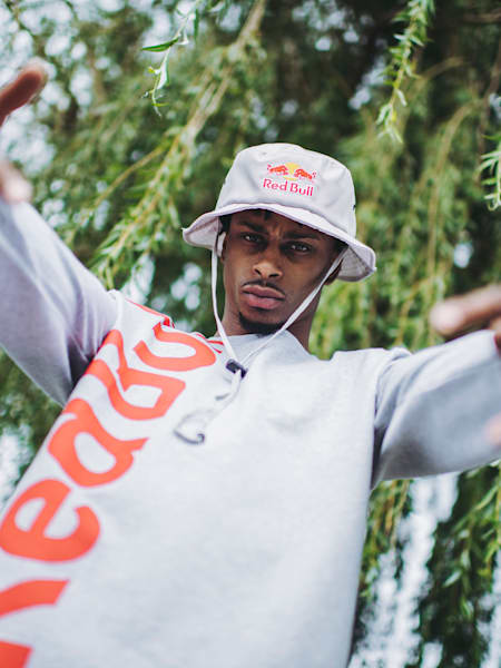 Portrait of Stalamuerte guesturing towards the camera.