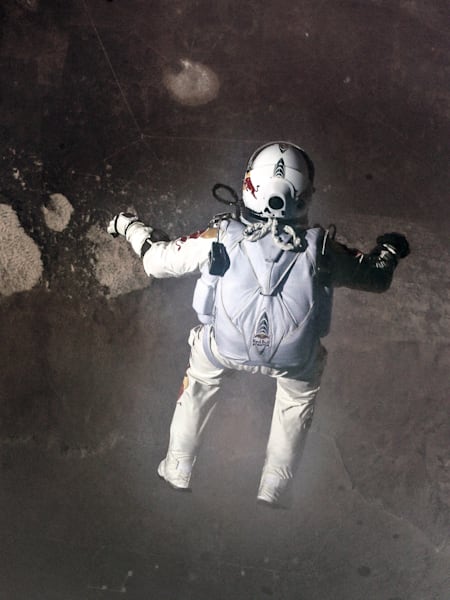 Falling in style: Felix Baumgartner leaps back to Earth. Seen below him is the landing site near Roswell, New Mexico.