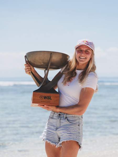 2025 WSL world champion Molly Picklum poses with the title trophy on Tavarua Island in Fiji