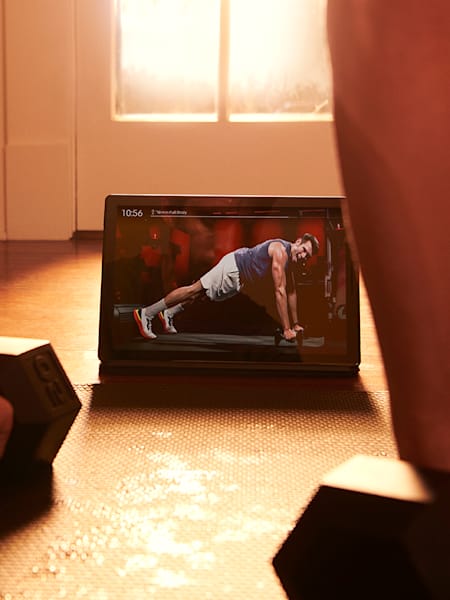 A person works out with Peloton Digital on their tablet