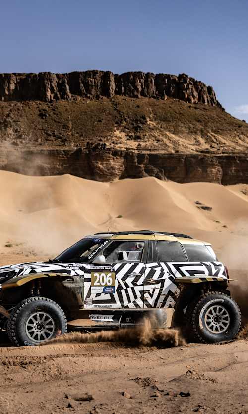 In 2024, Mathieu Baumel and Guillaume De Mévius race their Overdrive OT3 rally car, kicking up dust in the Moroccan desert dunes at the Rally Du Maroc.