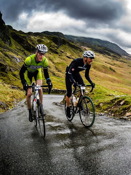 Two cyclists climbing up the ascent of the Hardknott pass.