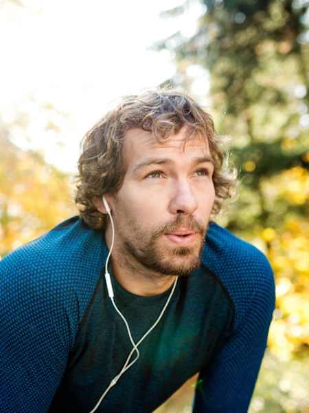 Man takes break from exercise while in forest.
