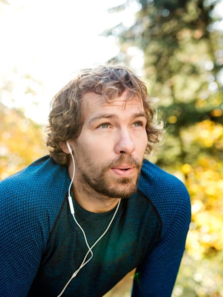 Man takes break from exercise while in forest.