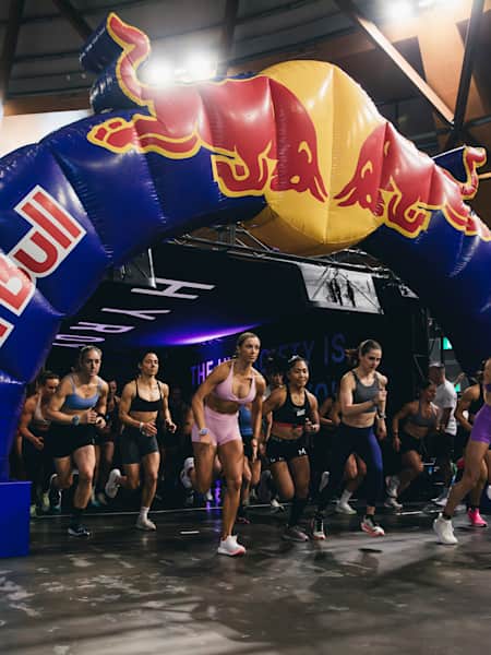 In 2024, female pro athletes race under the Red Bull arch at the Hyrox Sydney fitness competition