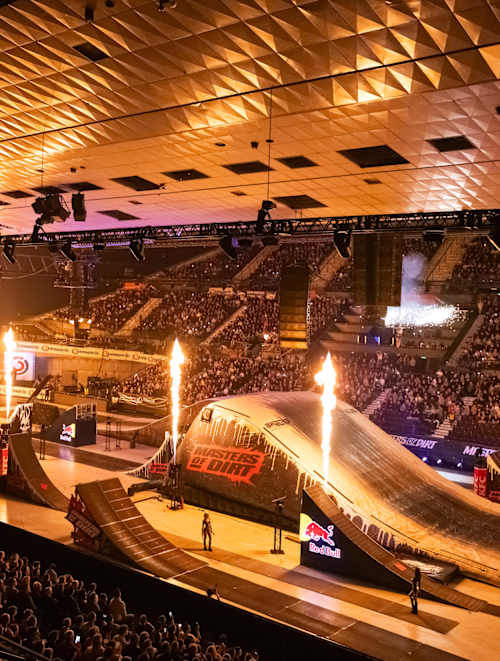 Fire ignites by two ramps for the Masters of Dirt Freestyle Showdown Tour 2025 in the arena