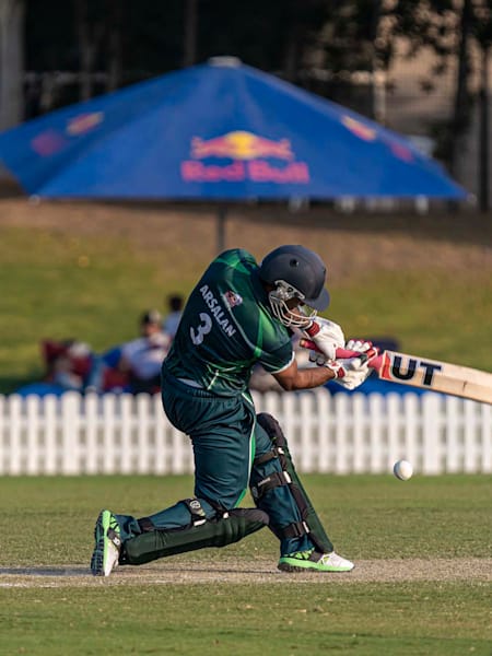 A batsman attempts a shot during a cricket match at a ground in Dubai.