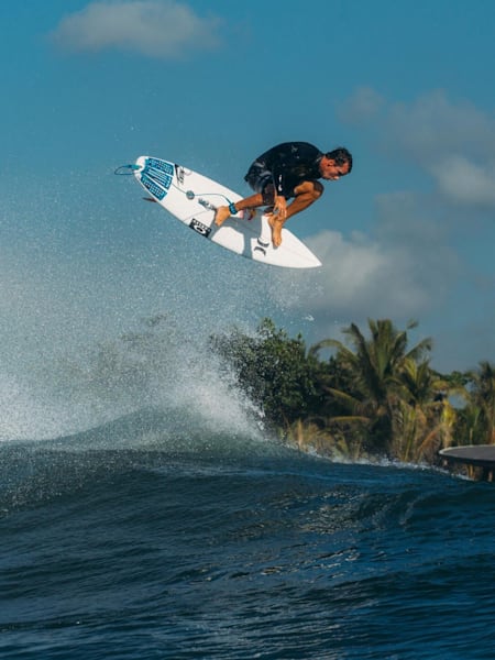 Surfer Julian Wilson performs a huge alley-oop aerial while surfing in Bali