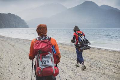 Competitors wrap up against an oncoming rain cloud during Race the Planet.