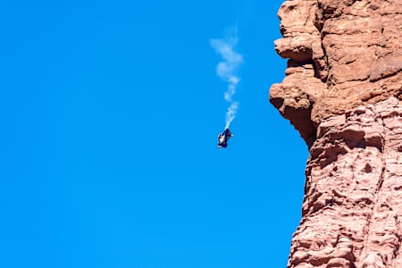 Miles Daisher of the Red Bull Air Force does a back flip in his wingsuit, following a B.A.S.E. jump from the tower known as Titan, part of the Fisher Towers near Moab, UT, USA on 28 October, 2014.