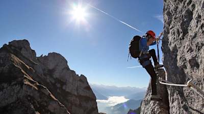 Climber makes their way to the top of a via ferrata in Austria.