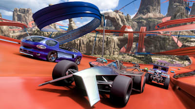Screenshot aus Forza Horizon 5: Hot Wheels zeigt mehrere Autos bei einem Rennen über einen Berg.