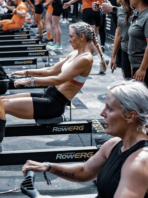 Los competidores se enfrentan a un reto de remo durante un evento de fitness HYROX