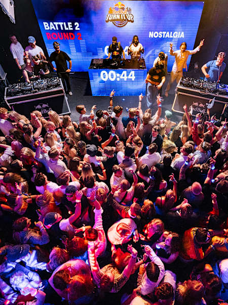 A vibrant audience in Stockholm electrifies the dance floor during Red Bull Turn It Up 2025, as DJs compete on stage, lights flash, and the city pulses with music and adrenaline