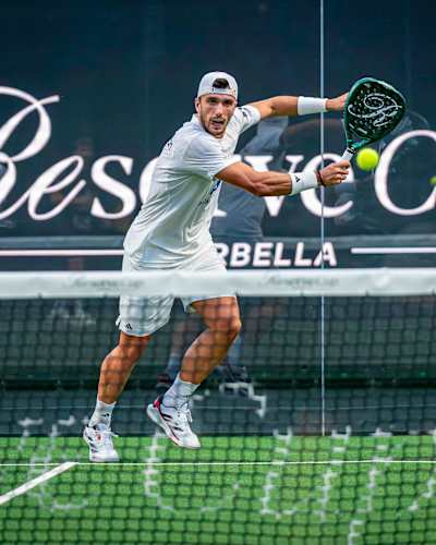 An electrifying moment at the Reserve Cup Marbella 2025, as a padel player smashes a forehand during a thrilling match on the prestigious court