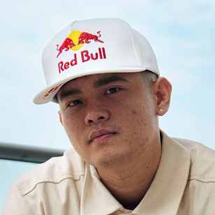 MT Pop, adorned in Red Bull gear, poses with a classic energy drink on February 12, 2025, against the picturesque backdrop of Dubai, United Arab Emirates