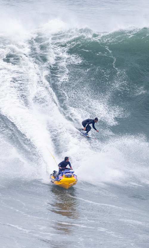 Lucas Chumbo surfing and Kai Lenny on the jetski in Nazaré, Portugal, on November 15th 2023.  