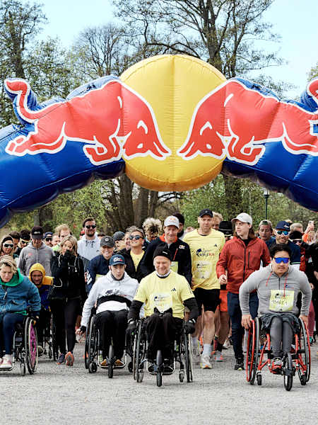 Participants of all abilities begin the Wings for Life World Run 2025 under the Red Bull arch in Stockholm, Sweden.