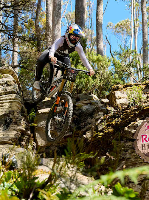 Gracey Hemstreet nimmt beim Training zur Red Bull Hardline 2026 im australischen Maydena Bike Park eine technische Abfahrt in Angriff, umgeben von schroffen Felsen und wilden tasmanischen Wäldern.