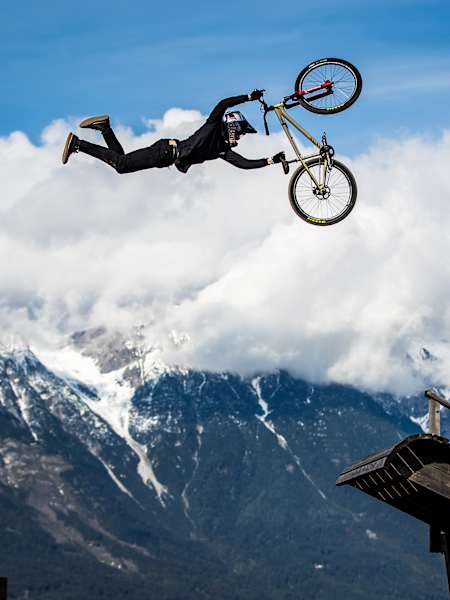 Thomas Genon saute avec son vélo lors de l'épreuve de VTT slopestyle du le Crankworx Innsbruck.