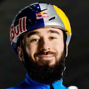 Denis Nikisha, wearing a Red Bull branded helmet and Kazakhstani uniform in Astana on 15 September 2025, is ready for high-speed ice action in this dynamic skating scene.