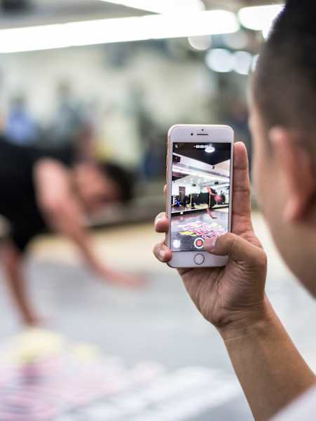 Una persona filma a un bailarín con su teléfono móvil.