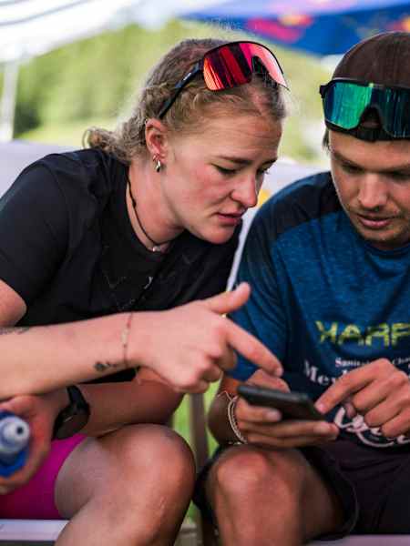 Celine Lorenz reviews race data and plans the next move during Red Bull X-Alps in Sankt Moritz, Switzerland, June 2025, embodying the adventurous spirit of Red Bull's legendary event