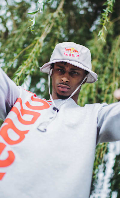 Portrait of Stalamuerte guesturing towards the camera.