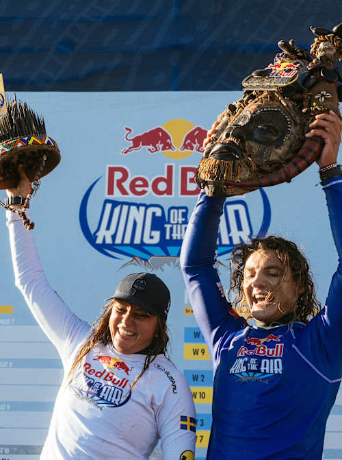 Nathalie Lambrecht y Lorenzo Casati celebran en el podio durante el tercer día del Red Bull King Of The Air 2025 en Ciudad del Cabo, Sudáfrica, levantando orgullosos sus trofeos únicos del evento.