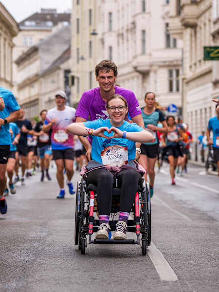 Runners and a wheelchair participant race through Vienna during the 2025 Wings for Life World Run, bringing Red Bull's spirit of inclusivity and energy to the city streets