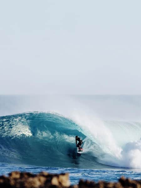 O surfista adolescente Riley Laing surfando um tubo azul no sul da Austrália