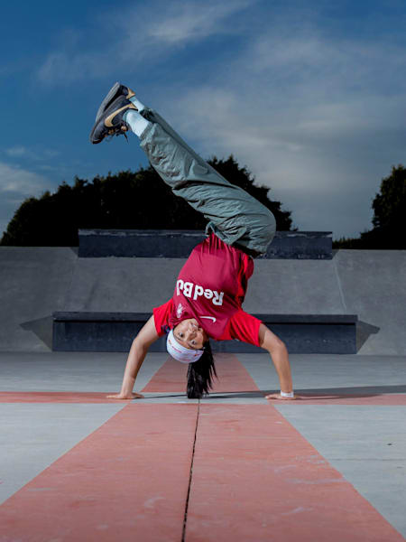 Logistx stands on her hands with the legs pointing to the side.